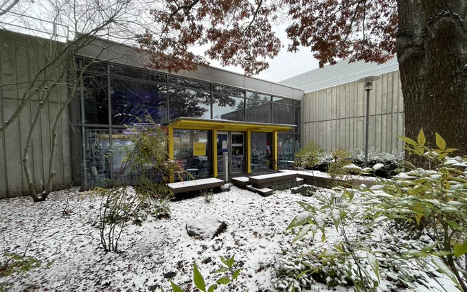 Wide shot of the entrance of the inclusive tech lab with trees up, scaring the main entrance and snow everywhere.