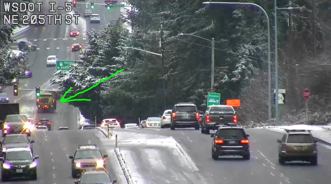 A WSDOT camera shows a plow truck along SR 104 near I-5. 