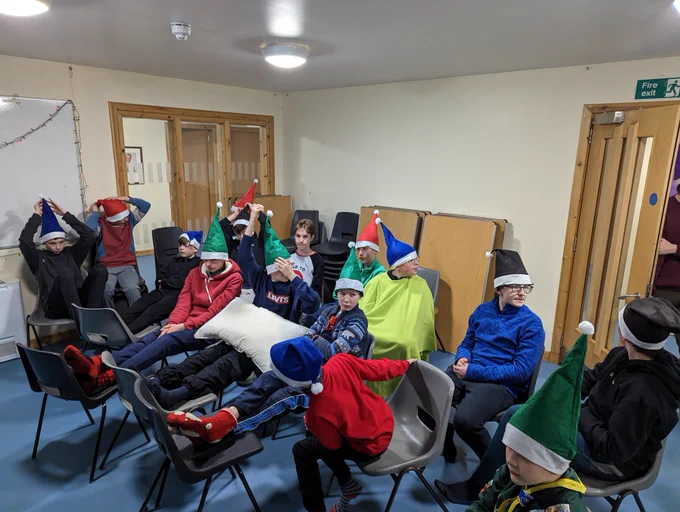 Scouts in Santa hats waiting for a film to start