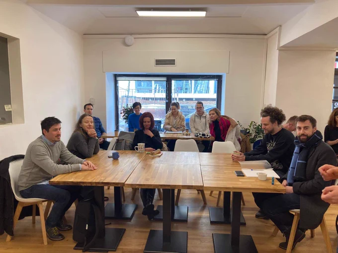 People attending the event are sitting around o table.