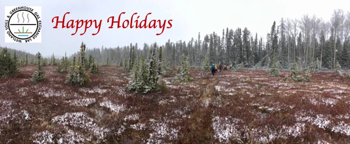 A snowy peatland with researchers walking, a lab logo and the words Happy Holidays