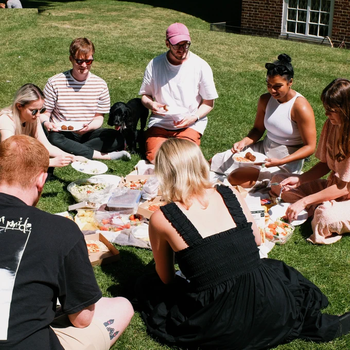 The team enjoying a picnic lunch on a sunny day. 
