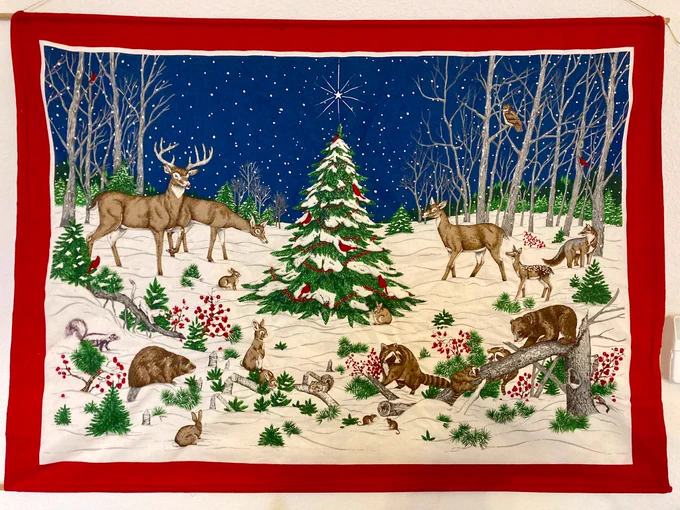 A Christmas tapestry with little animals sewn into it in a woodland scene, including a beaver.