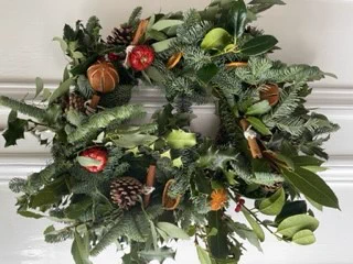 Christmas wreath of natural foliage with oranges and pine cones