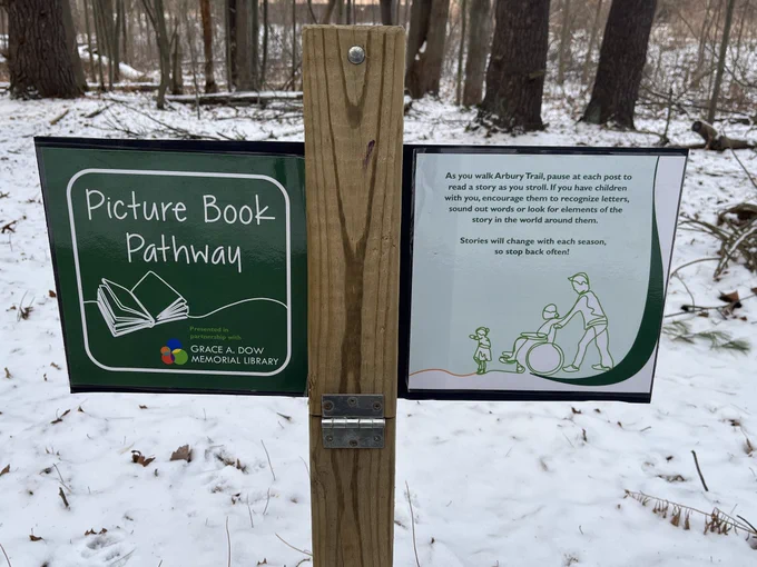 Sign along trail that says “Picture Book Pathway. As you walk Arbury Trail, pause at each post to read a story as you stroll. If you have children with you, encourage them to recognize letters, sound out words or look for elements of the story in the world around them. Stories will change with each season, so stop back often!”