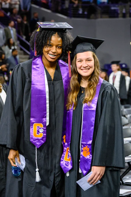 Two graduates posing for a photo pre-ceremony.
