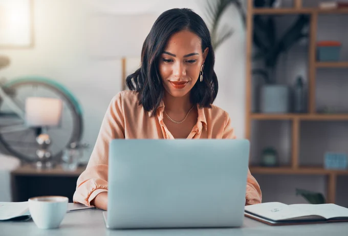 Person sitting at a desk and working on a laptop 