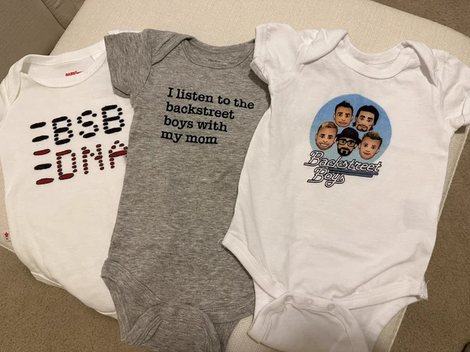 Photo with 3 baby onesies. First one says BSB DNA, second says I listen to the Backstreet Boys with my mom. Third one says Backstreet Boys with emoji faces of the BSB.