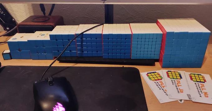 A set of Rubiks cube from 1 x 1 to 8 x 8 sitting on a desk, learning to cube website