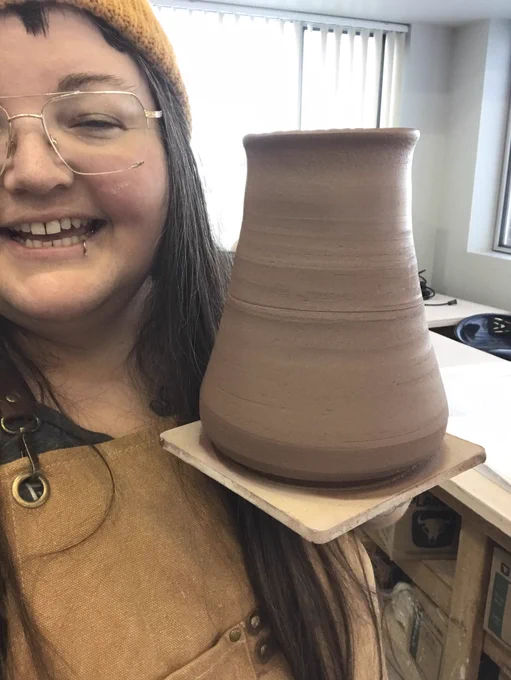 Woman holding a fresh clay pot next to her face