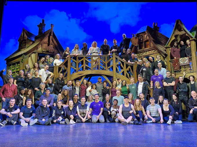 The full company of Beauty and the Beast poses on stage
