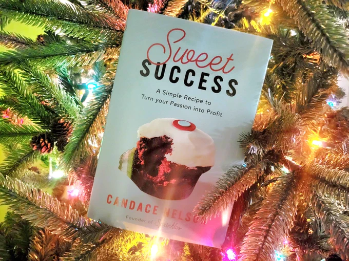 A hardback copy of the book Sweet Success, pictured propped inside a lit Christmas tree.