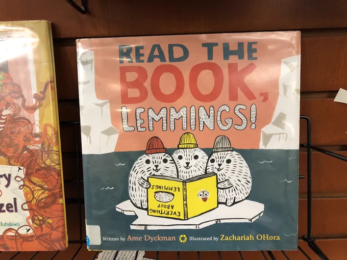 Read the Book, Lemmings! Written by Ame Dyckman, Illustrated by Zachariah OHora. On a library shelf.