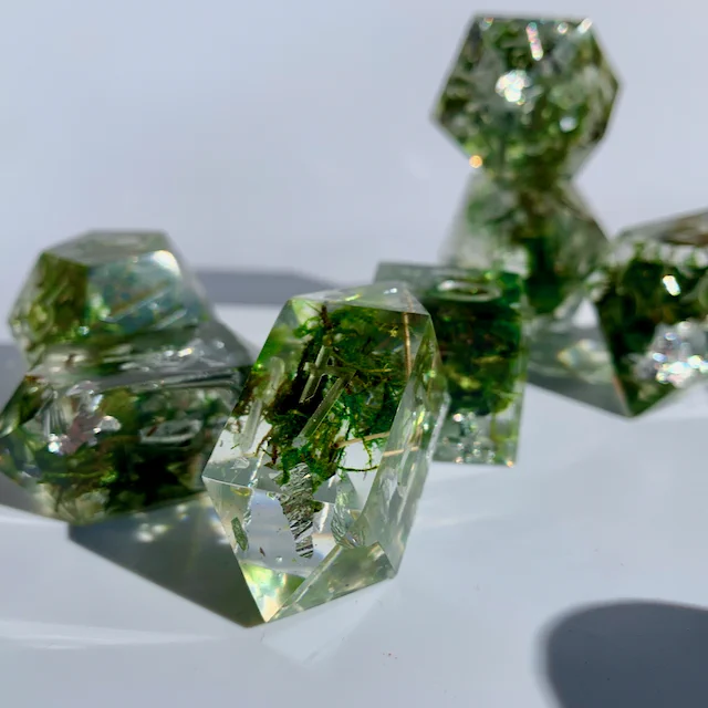 polyhedral dice for ttrpgs like dungeons and dragons. These dice have moss and silver leafing foil inclusions.