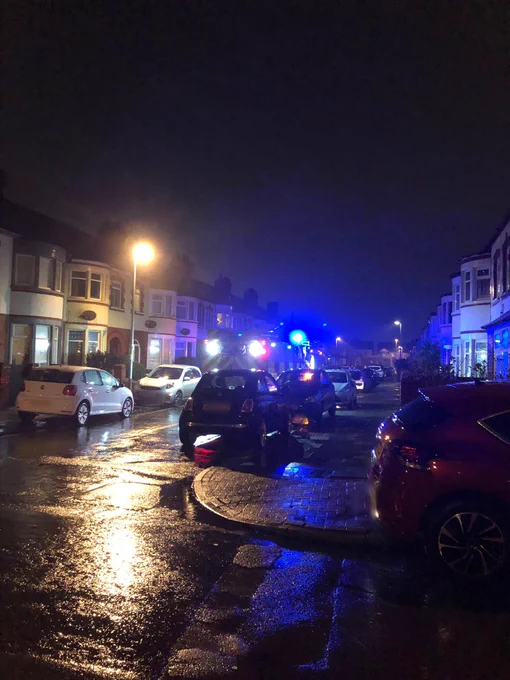 Fire engine on a street with parked cars either side