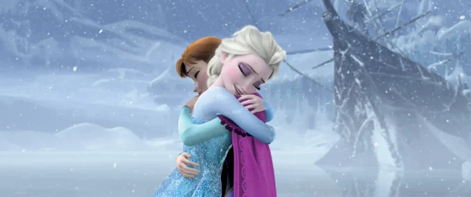 A still image from the Disney film Frozen. Ana and Elsa hug in the snow storm.