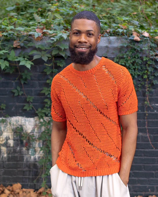 A photo of me wearing an orange shirt that I hand-crocheted.
