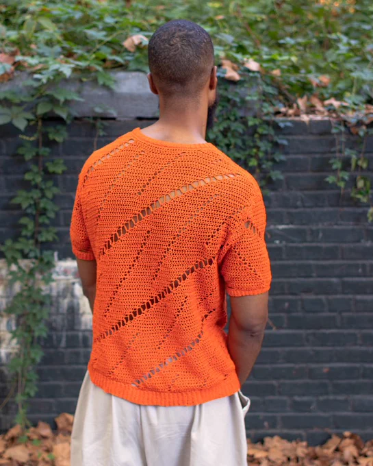 A photo of me wearing an orange shirt that I hand-crocheted.