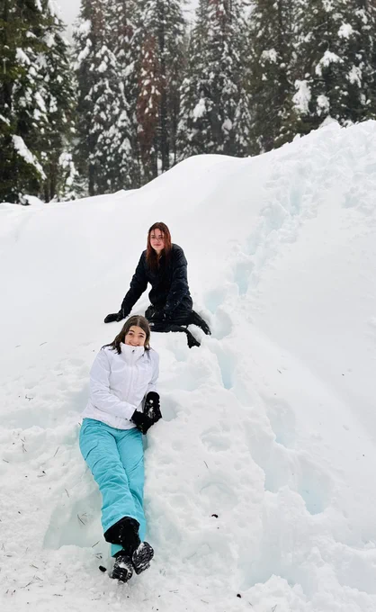 Teen girls sitting in wet snow.