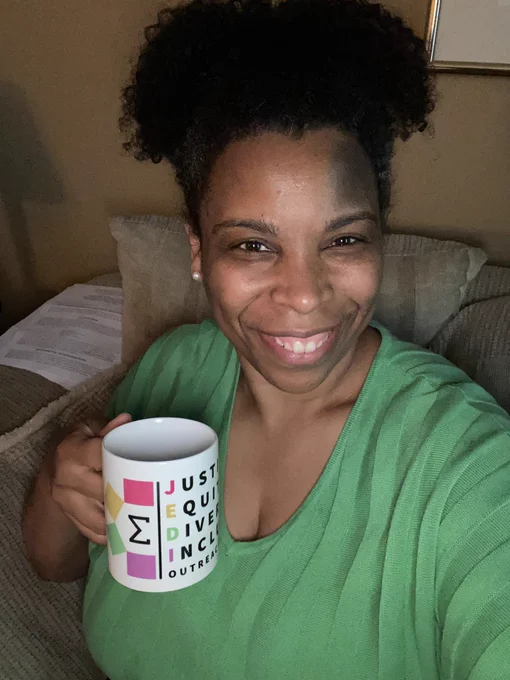 Holding a Justice, Equity, Diversity, and Inclusion (JEDI) Outreach Group mug