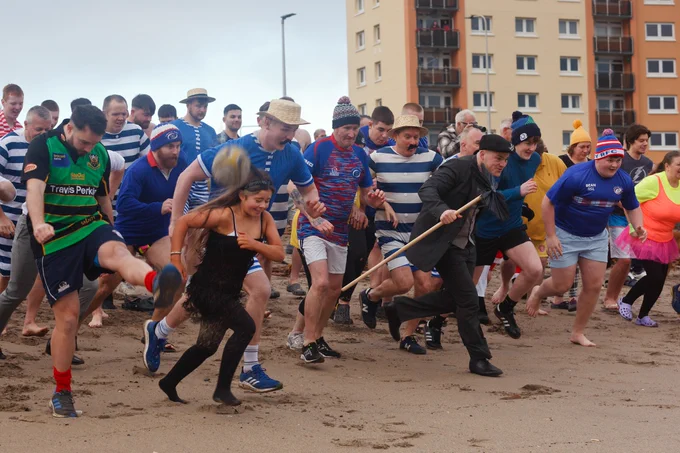 People running towards the sea to take part in the loony dook