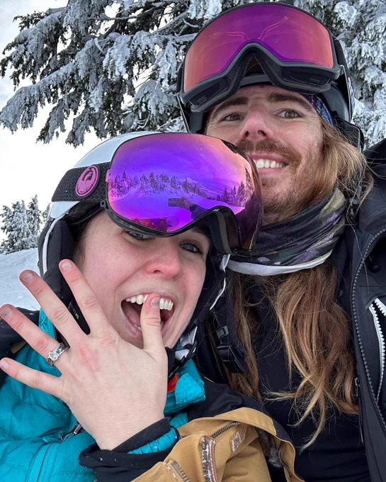 Aimee and JP smiling selfie showing off their new engagement rings
