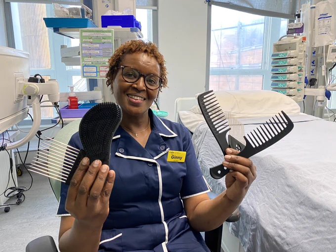 Ginny Wanjiro sat in a chair in her nursing uniform. She is smiling at the camera while holding a selection of combs. 