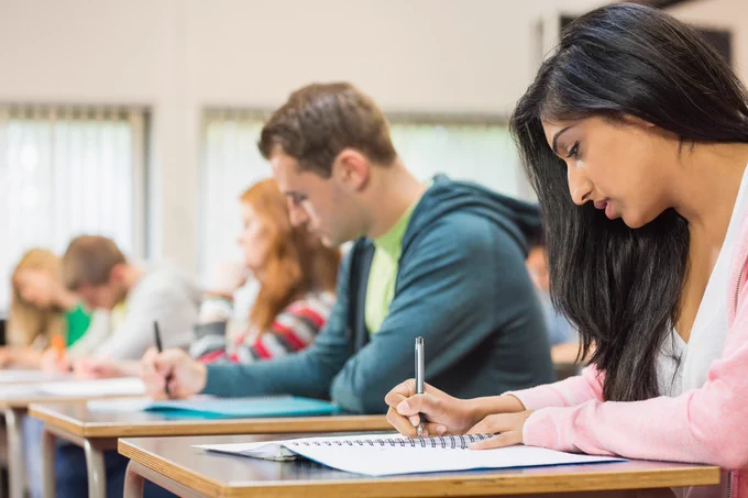 Image of students writing in a classroom.