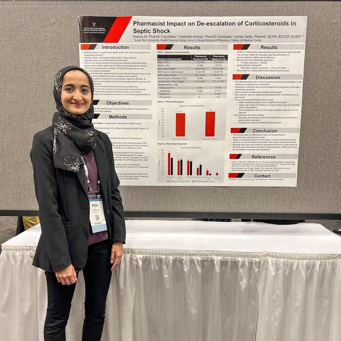 Female TTUHSC pharmacy student stands in front of her research poster at a conference.