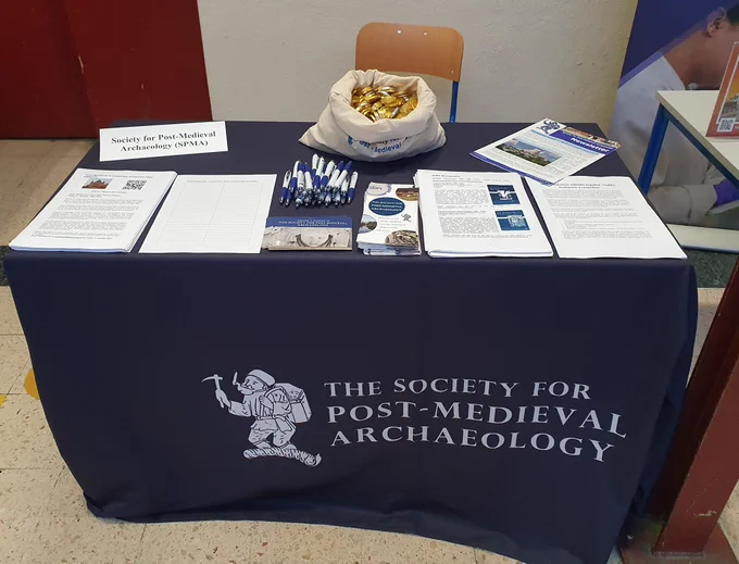 Table with selection of SPMA publications, flyers and a sack of chocolate coins.