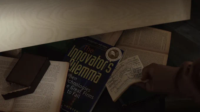 Scene still from "Glass Onion: A Knives Out Mystery" featuring Innosight co-founder Clay Christensen's book, "The Innovator's Dilemma."