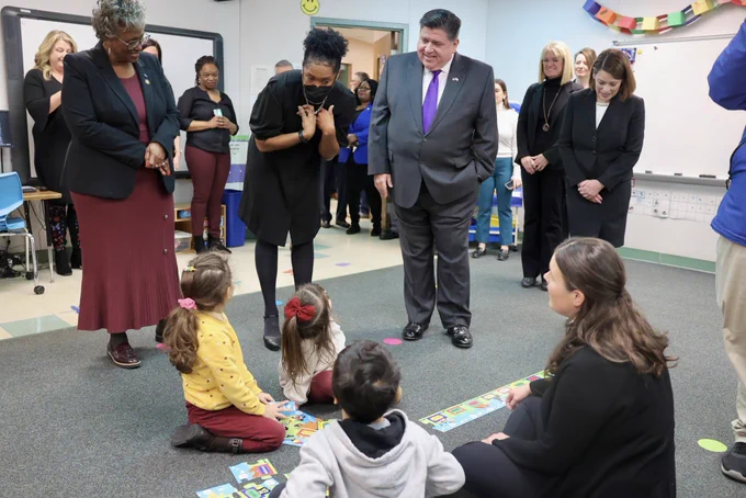 Governor Pritzker and Lt. Governor Stratton speak with children in a classroom.