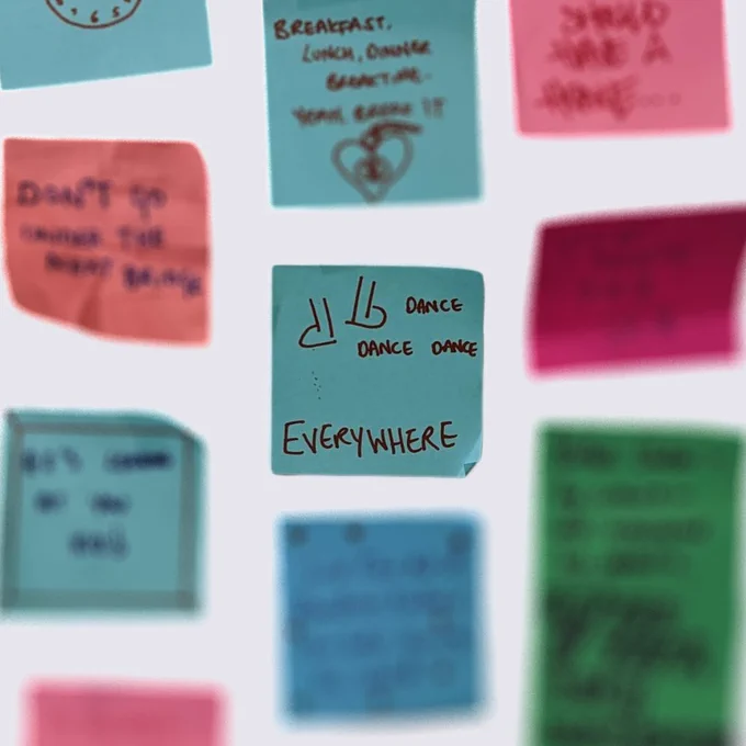 A graphic of post-it notes with one in the middle reading “Dance Dance Dance EVERYWHERE with an illustration of dancing feet”