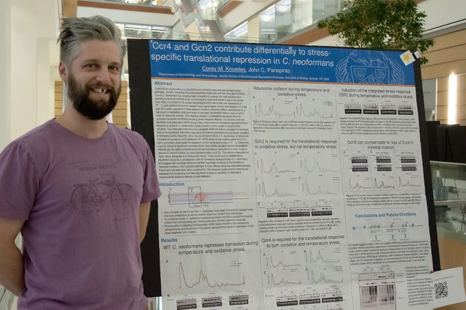 Doctoral student Corey M. Knowles stands near his poster