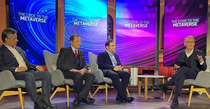four people are sitting on a chair in front of a colourful background