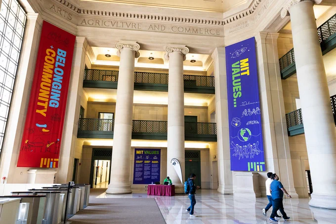 People walking in Lobby 7, colorful banners hanging from ceiling.