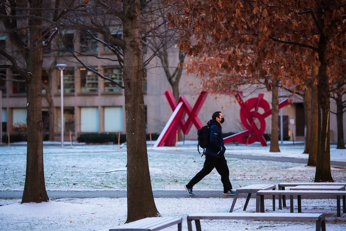 Person walking across Hockfield court on light snow.
