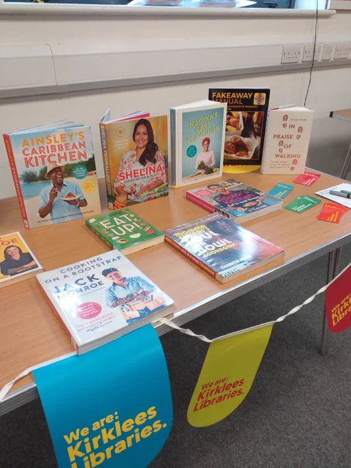 Book display showing healthy eating cookbooks, guides to cooking on a budget, walking books and library promotional material