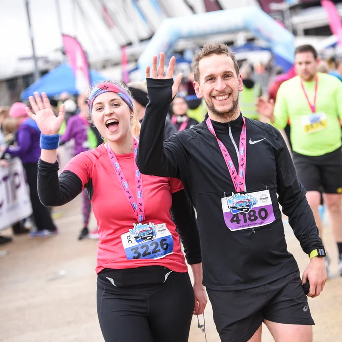 Image of charity run participants smiling and waving after completing the run