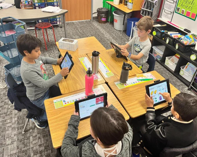 Student group navigating to and completing a Seesaw activity.