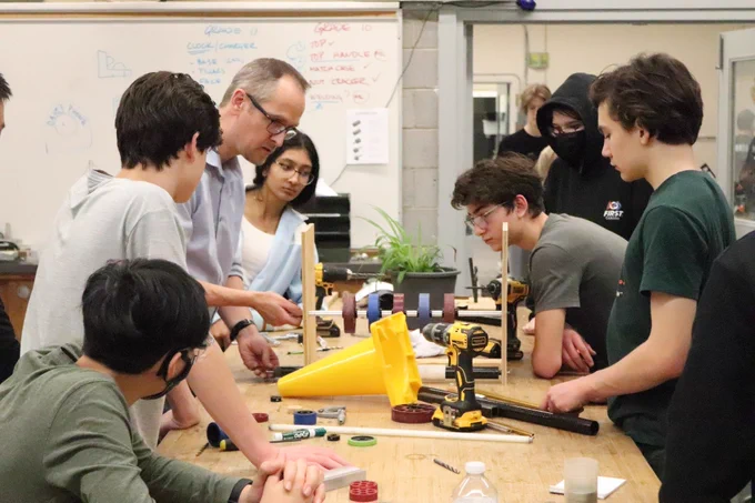 Mentor Rich with a group of Grade 9s, working on building an intake prototype.