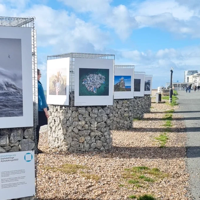 outdoor exhibition of 20 single photographic images displayed on the promenade in Worthing on a bright sunny day