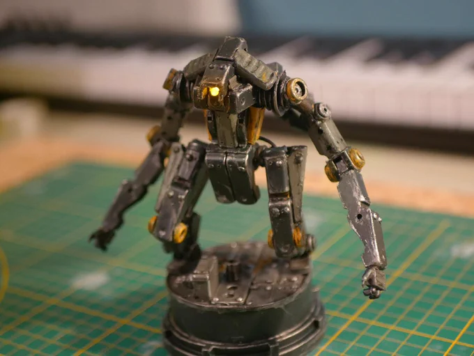 a cyclops robot made from clothespin and bead, it's painted and its unique eye is bright