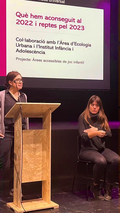 Yo de pie detrás  un atril hablado sobre los parques y una mujer a lado mio que hacía de intérprete en lengua se signos.
