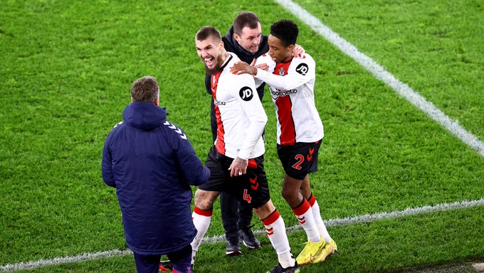 Lyanco grins widely at a Southampton backroom staff member after assisting a goal.