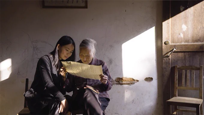 Still from Violet Du Feng's documentary "Hidden Letters" about the secret Chinese language of Nushu. Photo shows two of the film's main characters -- a younger women and her older mentor -- looking over a paper that contains the younger woman's Nushu writing.