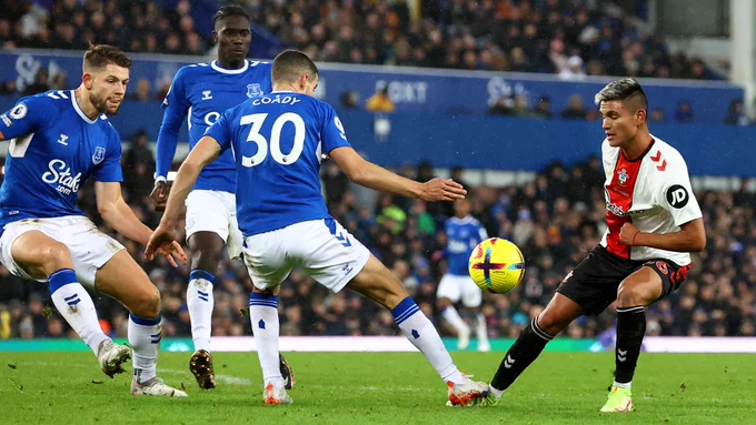 Charly Alcaraz plays a chipped pass around an Everton defender who is attempting to challenge for the ball.