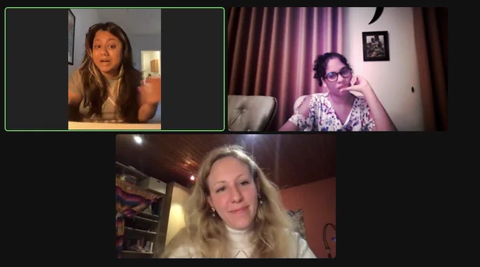 Screenshot of a zoom screen with three panels: Friederike, with long blonde hair and a white sweater on the bottom; Rohini, with long black hair and lighter highlights and a gray t-shirt in the upper left; and Shannel, with black hair pulled back, round black glasses, and a white patterned shirt in the upper right. Rohini is in the middle of speaking as Friederike and Shannel listen in.