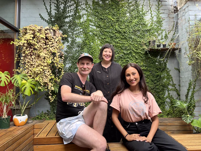 Jason Moore, Vanessa Toholka, & Urvi Majumdar happily gather in the Triple R courtyard surrounded by ferns and climbers.