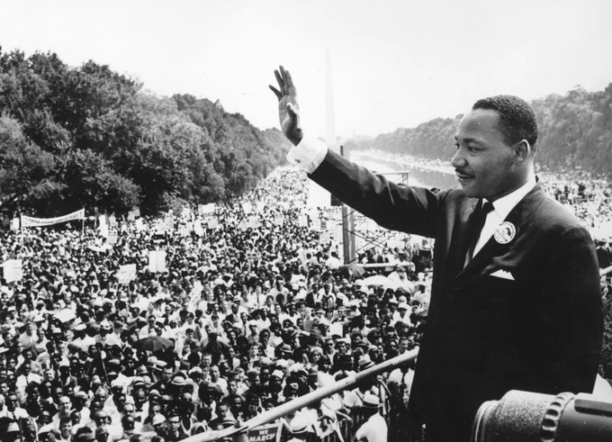 Photograph of Dr. Martin Luther King, Jr., waving to crowd.
